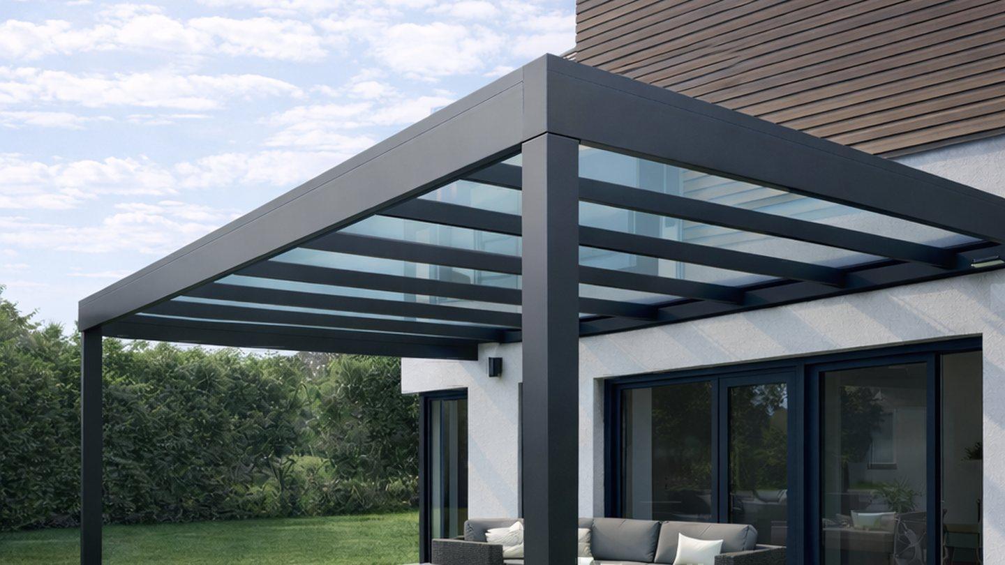 Terrassenüberdachung aus Aluminium mit Glasdach an einer Holzfassade
